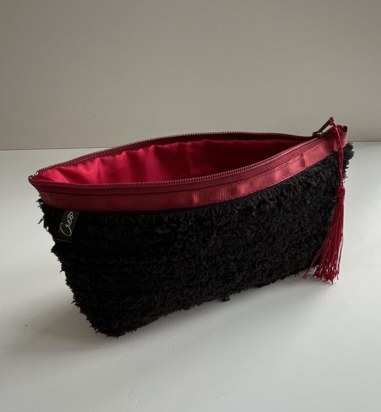 Melns maciņš ar sarkaniem akcentiem